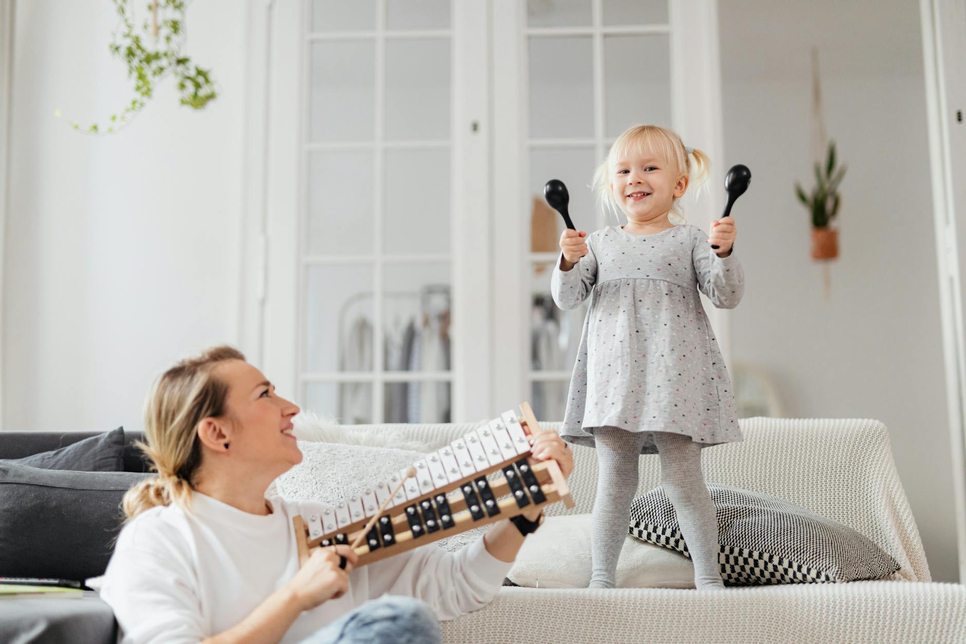 mother and little daughter holding rattles and chromatic bells